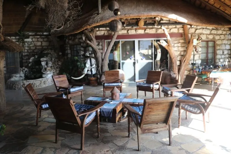 Comedor exterior bajo los árboles, preparado para cenas privadas en plena naturaleza africana.